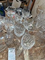 Top view showing 11 Waterford crystal goblets with mixed cut patterns placed on a countertop, some upside down