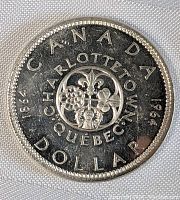 Reverse side of the coin showing 'CANADA CHARLOTTETOWN QUEBEC DOLLAR 1964' with floral emblem in the center.