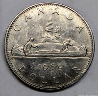 Reverse side of the coin showing the voyageur canoe with two men, trees, and Northern Lights design with date 1969 and inscriptions 'CANADA DOLLAR'.