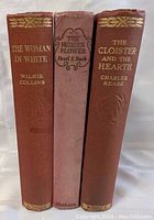 Front view of the three antique hardcover books with titles clearly visible on the spines.