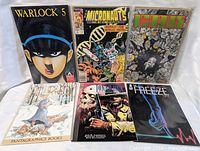 Photo showing all six comic books laid out together: Warlock #5, The Micronauts #6, Doom, Fantagraphics Books comic, Jon Sable, Freeze