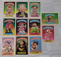 Photo showing front side of 11 Garbage Pail Kids cards arranged in grid showing character artwork and names.