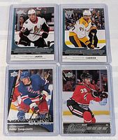 Four NHL rookie hockey cards in protective sleeves featuring Christian Jaros, Alexandre Carrier, Bobby Sanguinetti, and Michael Murray.