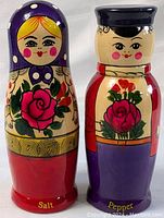 Front view of the hand-painted Russian nesting doll salt and pepper shakers showing detailed floral patterns and facial features.