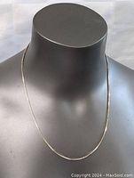 Front view of the sterling silver necklace on black mannequin showing full length and flat chain link style.