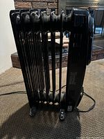 Side view of the black Honeywell oil-filled radiator heater showing fins and housing.