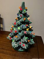 Ceramic Christmas tree decorated with colorful bulbs displayed on wooden surface