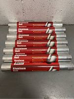 Seven aluminum foil rolls stacked horizontally showing the labels and metallic foil ends.