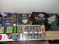 Assorted board and card games including puzzle, poker set, Dirty Minds, Personally Incorrect, Jenga games, Uno Express, and poker chips