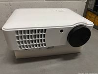 White Favi LED projector front angle showing ventilation and lens