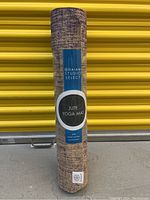 Photo of rolled Gaiam Studio Select Jute Yoga Mat with label showing brand and eco-friendly claim.