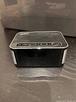 Front view of the Musky wireless alarm clock showing top buttons and brand name.