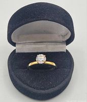 14k gold plated ring with a round solitaire cubic zirconia stone displayed in a black velvet ring box.