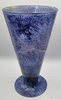 Front and side view of the blue marbled art glass vase showing its conical flare and overall shape.
