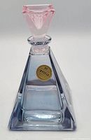 Italian crystal perfume bottle with pink triangular stopper and clear body, label visible on front.