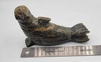 Soapstone seal carving placed next to ruler showing approx 6 inch length