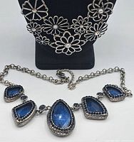 Blue gemstone necklace with five large blue faceted stones, decorative silver tone edges and chain