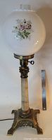 Full view of vintage banquet lamp showing cast brass base, alabaster column, and floral glass globe with clear chimney
