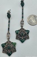 Full front view of vintage drop earrings with a coin for scale showing one earring with damage on green stone