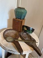 Six vintage Chinese items arranged on a small round table including crockery, molds, a box and a letter opener.