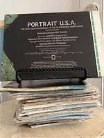 Stack of vintage National Geographic maps with visible front cover of 'Portrait U.S.A.' photomosaic map produced by National Geographic Society and collaborators.