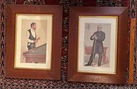 Pair of framed vintage Vanity Fair snooker prints in solid wood frames resting against a patterned carpet.