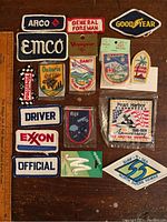 Overview of 16 vintage embroidered patches featuring car racing, gas station logos, travel destinations, and commemorative events