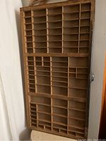 Front view of the vintage wooden printers tray showing multiple compartments of various sizes.