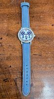 Front view of the Mickey Mouse watch with denim band showing the dial and strap.