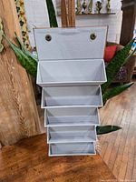 Foldable storage case expanded to show multiple compartments with white interior