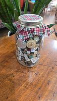 Ball jar filled with assorted buttons seen from the front, showing top and contents inside jar.