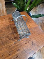 Side angle of the silver plated cracker holder showing rust and decoration