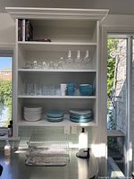 Image showing shelves with dishes, glasses, mugs, bowls, cookbooks, and accessories on countertop