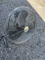 Front and side view of large steel cage floor fan, showing metal blades and protective cage