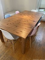 Top-down view of assembled table with six chairs showing wood grain and tabletop finish