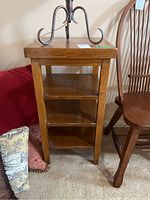 Full view of the oak wood shelf showing its shape, size, and three shelf compartments.