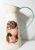 Full view of the vintage style metal pitcher showing overall shape, handle, and floral decal.