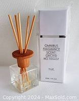 Photo of one Omnibus Orchid fragrance diffuser in glass bottle with reeds inserted and wooden top, showing diffuser and liquid level.