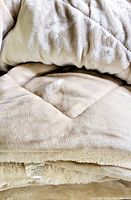 Close-up photo showing soft velvety taupe fabric exterior with visible quilted pattern and folded edge.
