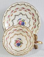 Top view of the tea cup placed inside the saucer showing detailed floral pattern and gold decorations.