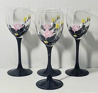 Set of 4 Luminarc wine goblets with black stems and floral decoration on clear glass bowls.