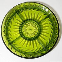 Top view showing full round avocado green glass dish with five divisions and leaf pattern design.