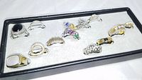 Full set of 12 fashion rings in black tray on light gray velvet.