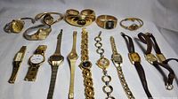 Photo showing 15 women's gold tone vintage watches arranged flat showing diversity in band styles and watch faces