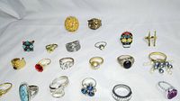 Rings arranged in 2 rows against white background showing various styles and stones