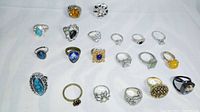 Top-down view of the 20 fashion costume rings showing variety of stones and mixed metal bands.