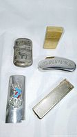Photo of 5 collectible lighters showing a variety of shapes, sizes, materials and decorative details