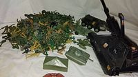 Photo showing green and tan plastic army men figures, green plastic military vehicles, and black Iron Panther tank with decals and extended cannon.