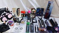 Overview of Halloween makeup products, hair color spray cans, costume accessories, and novelty items arranged on tabletop.