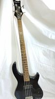 Full front view of Playmate black electric bass guitar against a white backdrop, showing body, neck and headstock.
